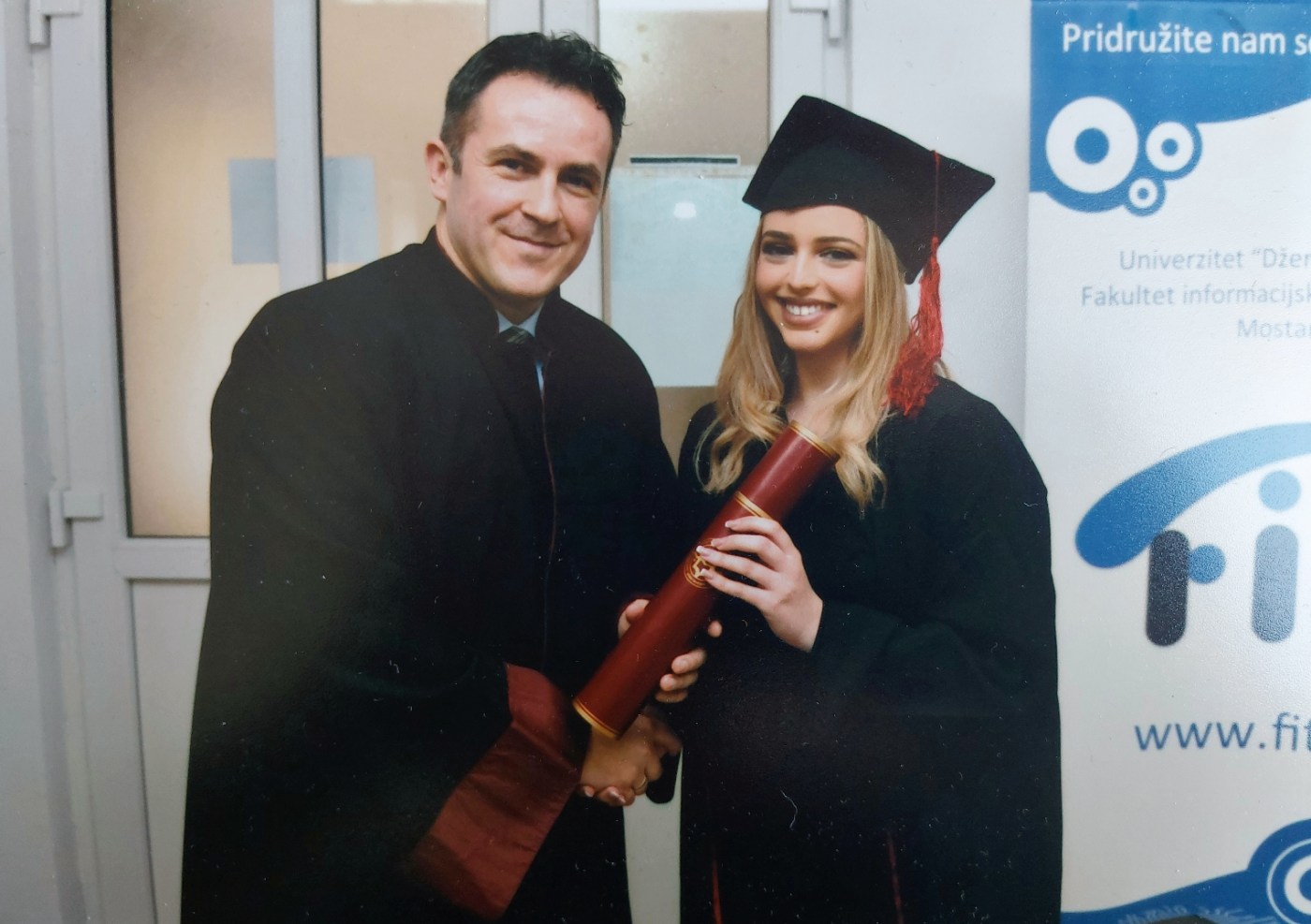 Selma receiving her diploma from a professor at the Faculty of Information Technology
